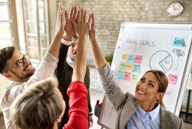 happy-business-team-with-raised-hands-celebrating-their-success-office_637285-7056
